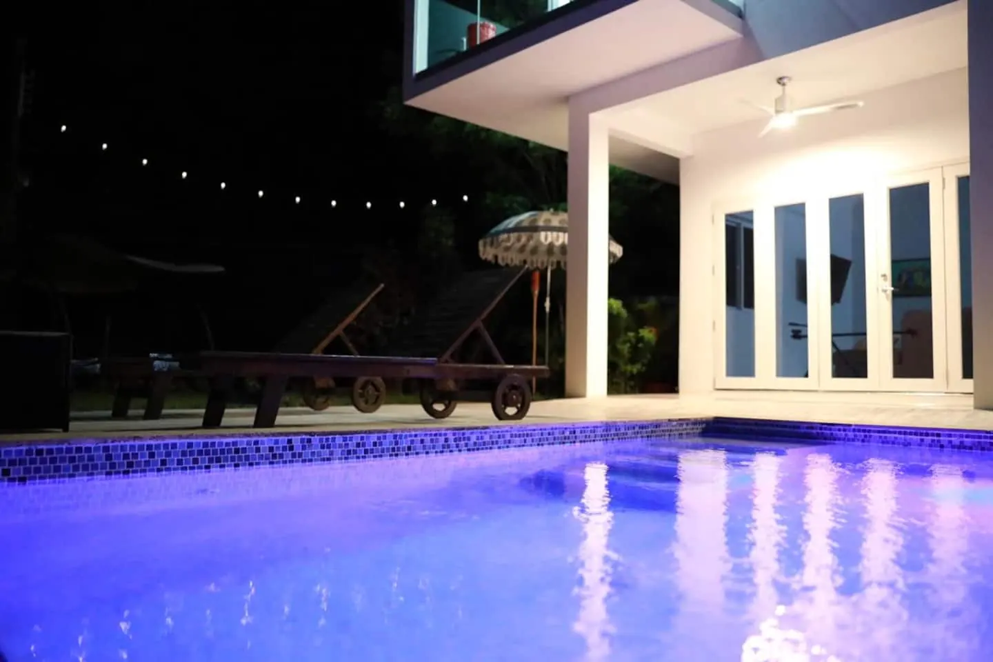Glory’s pool and covered terrace illuminated at night.